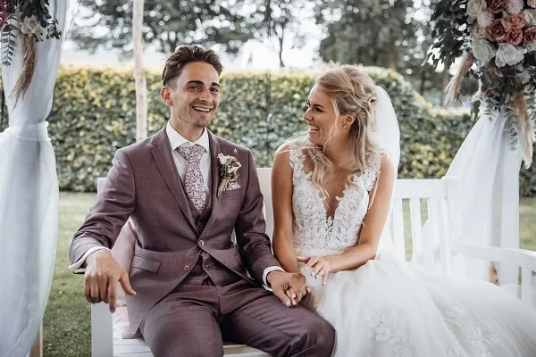 Stralend bruidspaar trouwt in achtertuin van ouders.